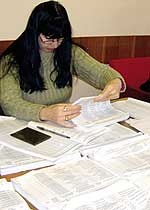 Сотрудник рабочей группы Светлана Тишина проверяет списки избирателей